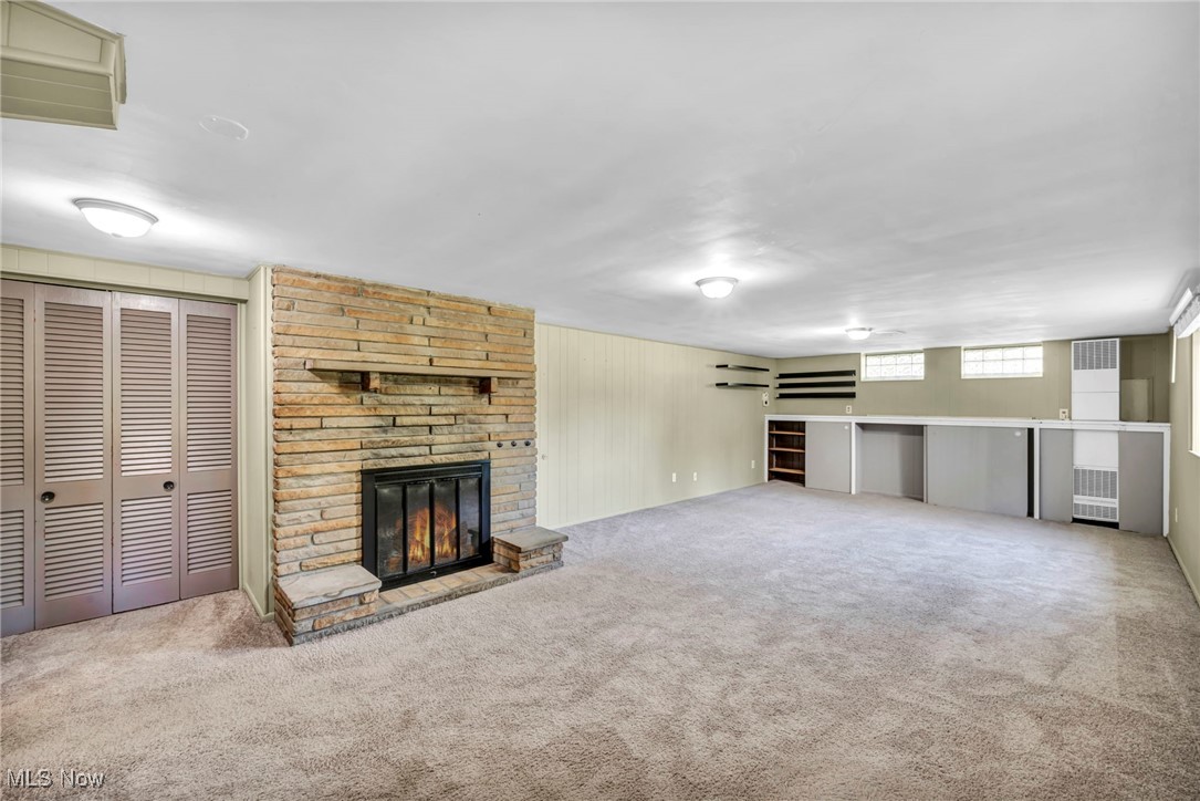4523 Oakes Road Brecksville, OH 44141 - Photo 33 of 50 Unfurnished living room featuring a stone fireplace, carpet floors, and a heating unit