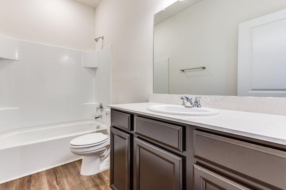 205 Briar Cove Anna, TX 75409 - Photo 7 of 11 Bathroom featuring shower / washtub combination, vanity, and dark wood-style flooring