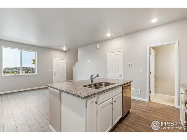a kitchen with a sink a mirror and wooden floor