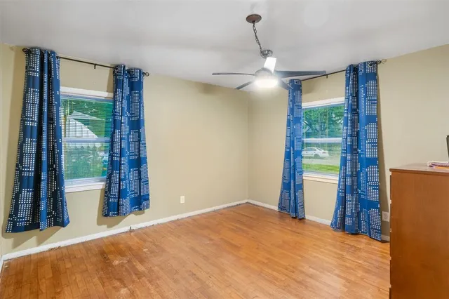 a bedroom with a bed and a dresser next to a window