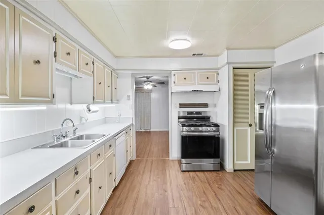 a kitchen with stainless steel appliances a stove sink and refrigerator
