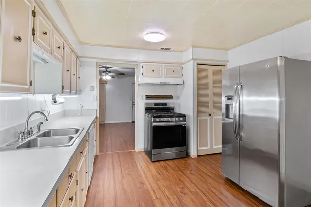 a kitchen with kitchen island granite countertop a sink cabinets and stainless steel appliances