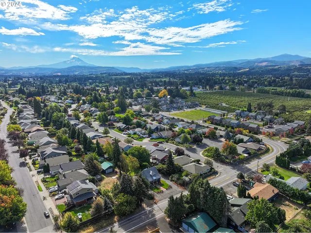 an aerial view of a city with lots of residential buildings and mountain view in back