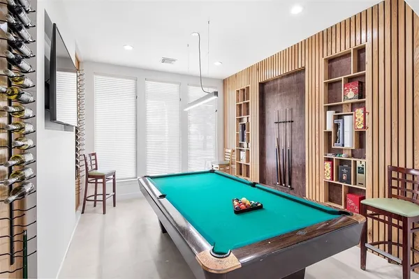 a room with pool table and windows