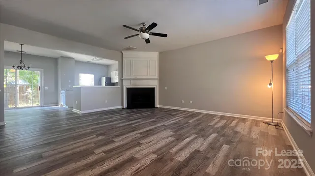 a view of empty room with wooden floor and window