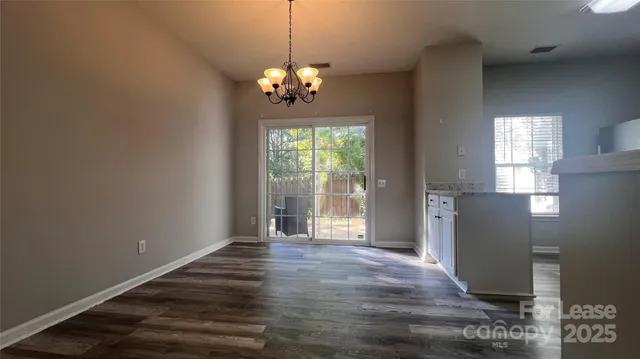 a view of a room with wooden floor and windows