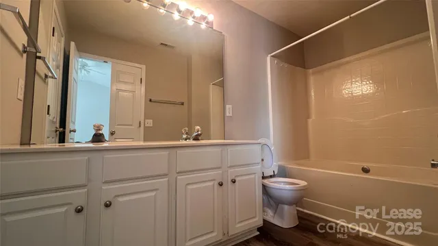a bathroom with a granite countertop sink a toilet and a mirror