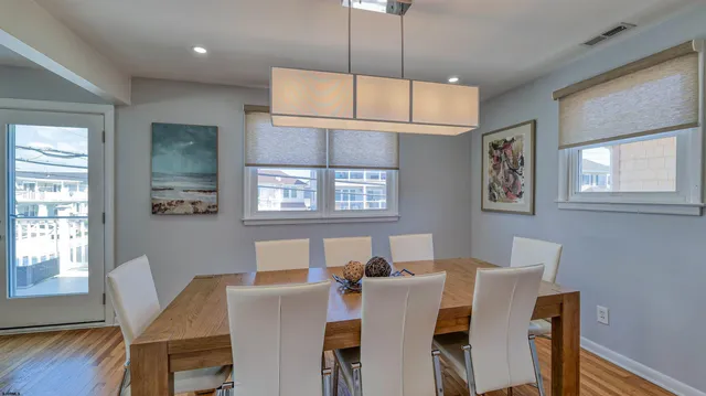 a view of a dining room with furniture a chandelier and wooden floor