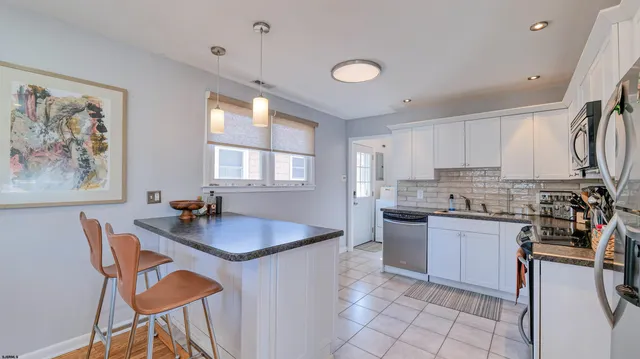 a kitchen with granite countertop a sink stove and cabinets