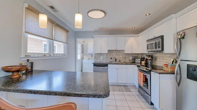 a kitchen with stainless steel appliances granite countertop a sink dishwasher stove top oven and cabinets with wooden floor