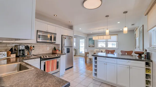 a kitchen with stainless steel appliances a sink stove and cabinets