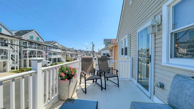 a view of a house with wooden deck and furniture