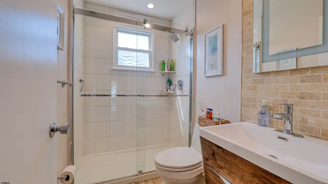 a bathroom with a sink a toilet and shower