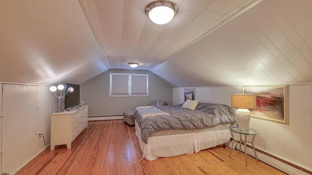 a spacious bedroom with a bed and a wooden floor