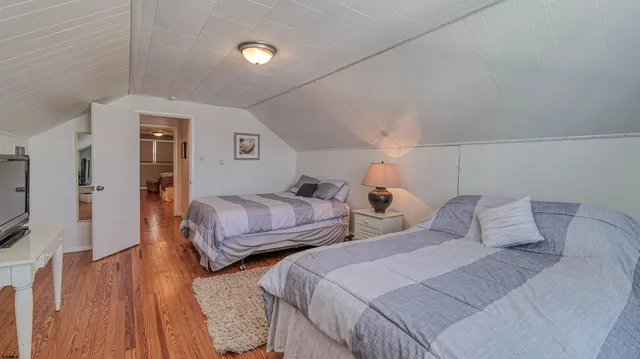 a bedroom with two beds and a flat screen tv