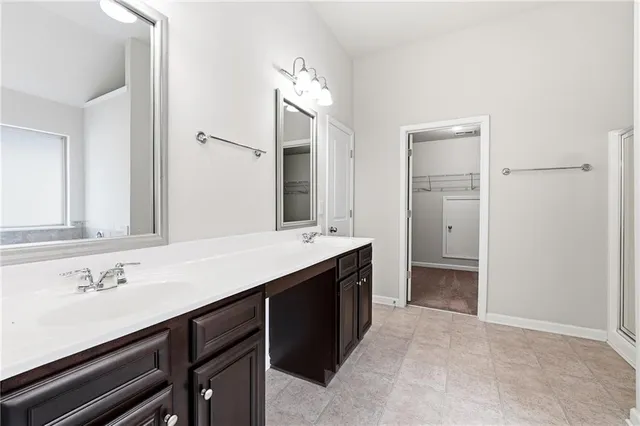 a spacious bathroom with a double vanity sink and a mirror