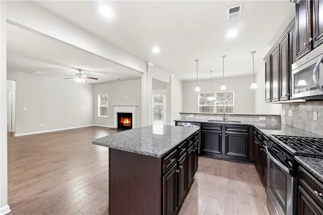 a kitchen with granite countertop a stove top oven sink and cabinets