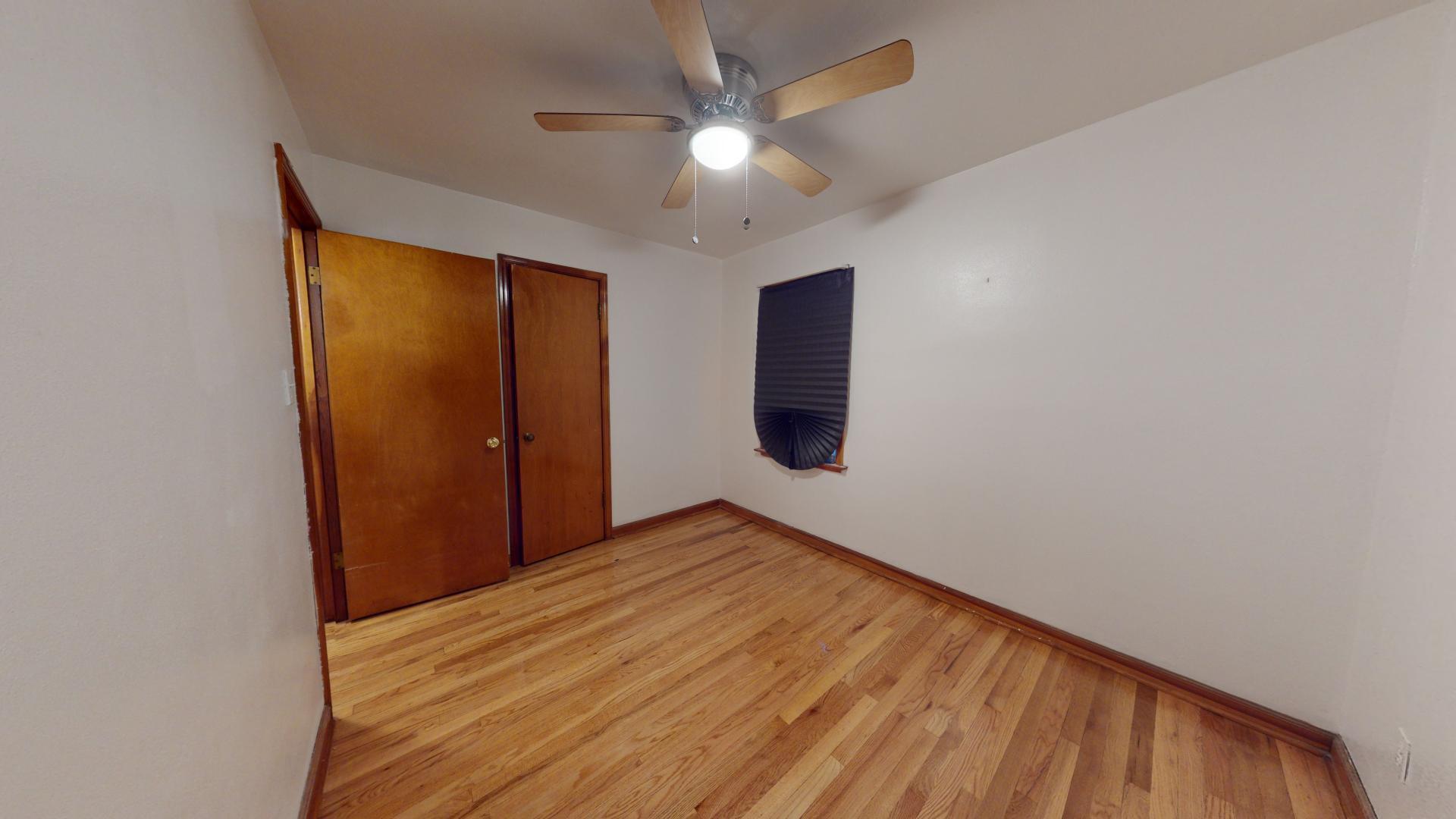 4377 Kentucky Street Gary, IN 46409 - Photo 14 of 20 a view of an empty room with wooden floor and a ceiling fan