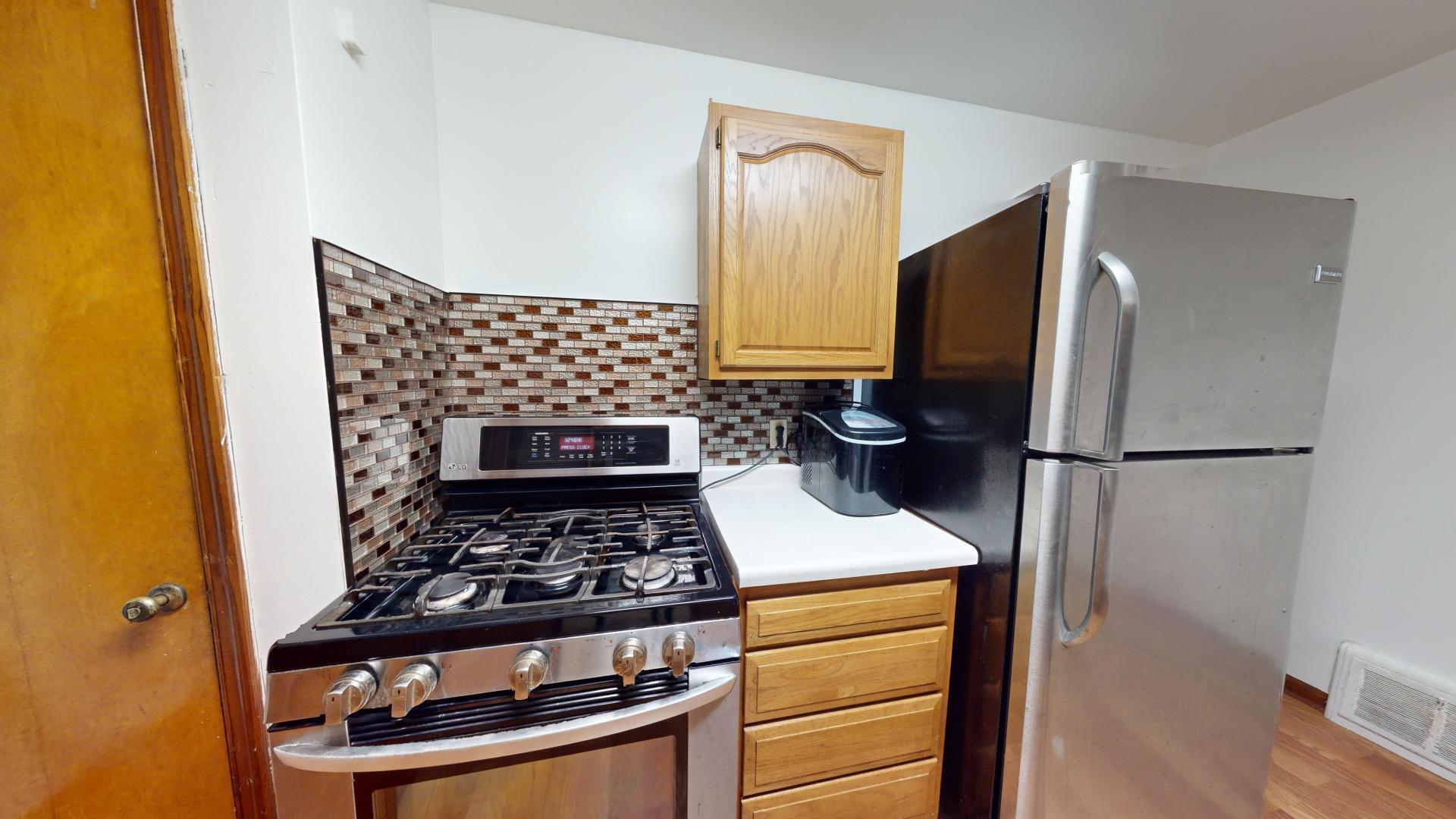 4377 Kentucky Street Gary, IN 46409 - Photo 8 of 20 a kitchen with a refrigerator and a stove