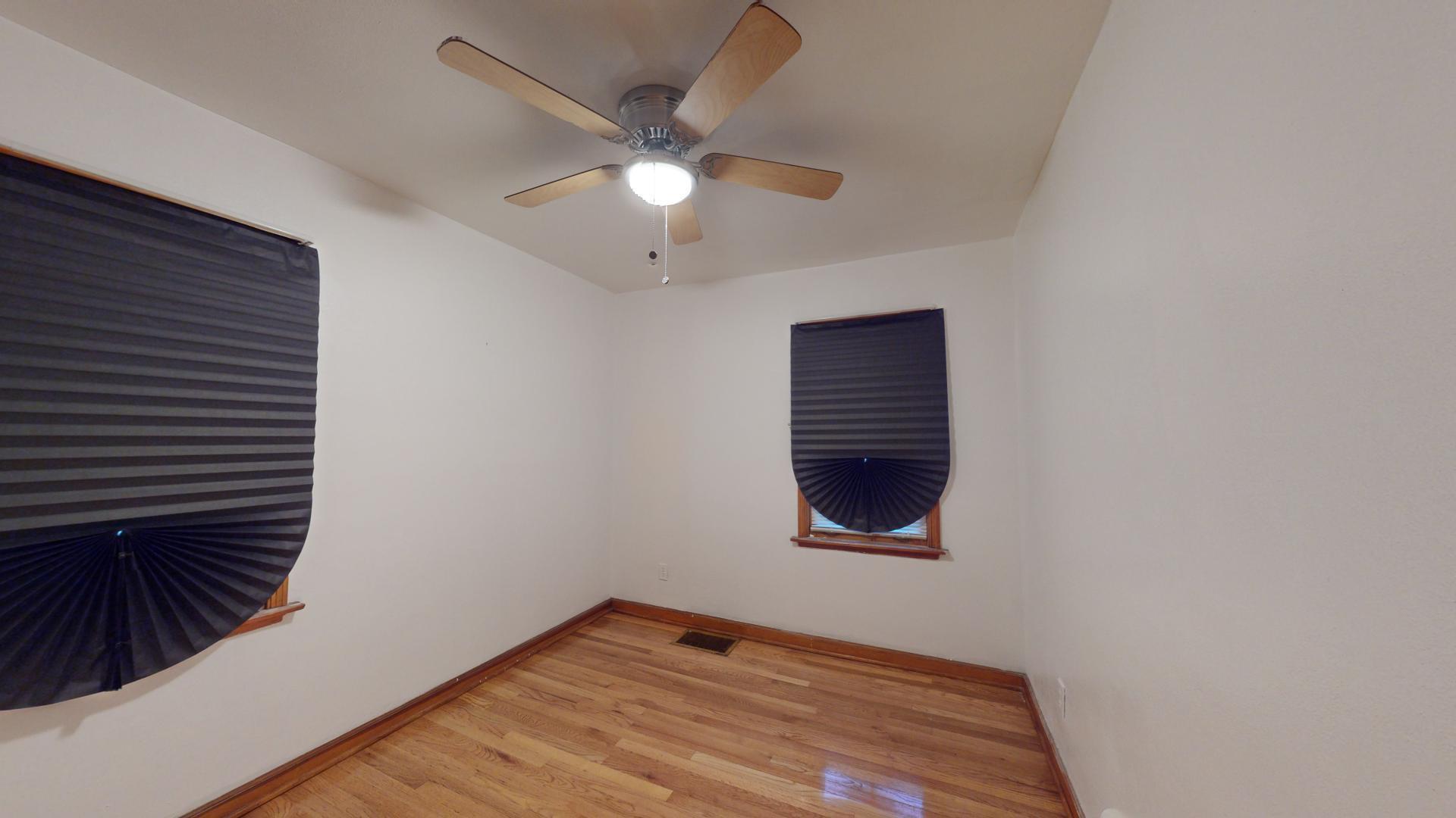 4377 Kentucky Street Gary, IN 46409 - Photo 10 of 20 a view of an empty room with wooden floor and a ceiling fan