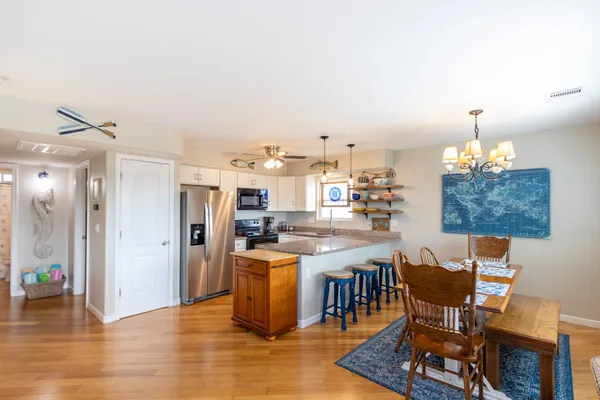 a kitchen with stainless steel appliances a dining table chairs and chandelier