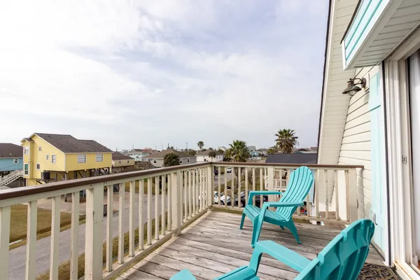 a view of a balcony with wooden chairs