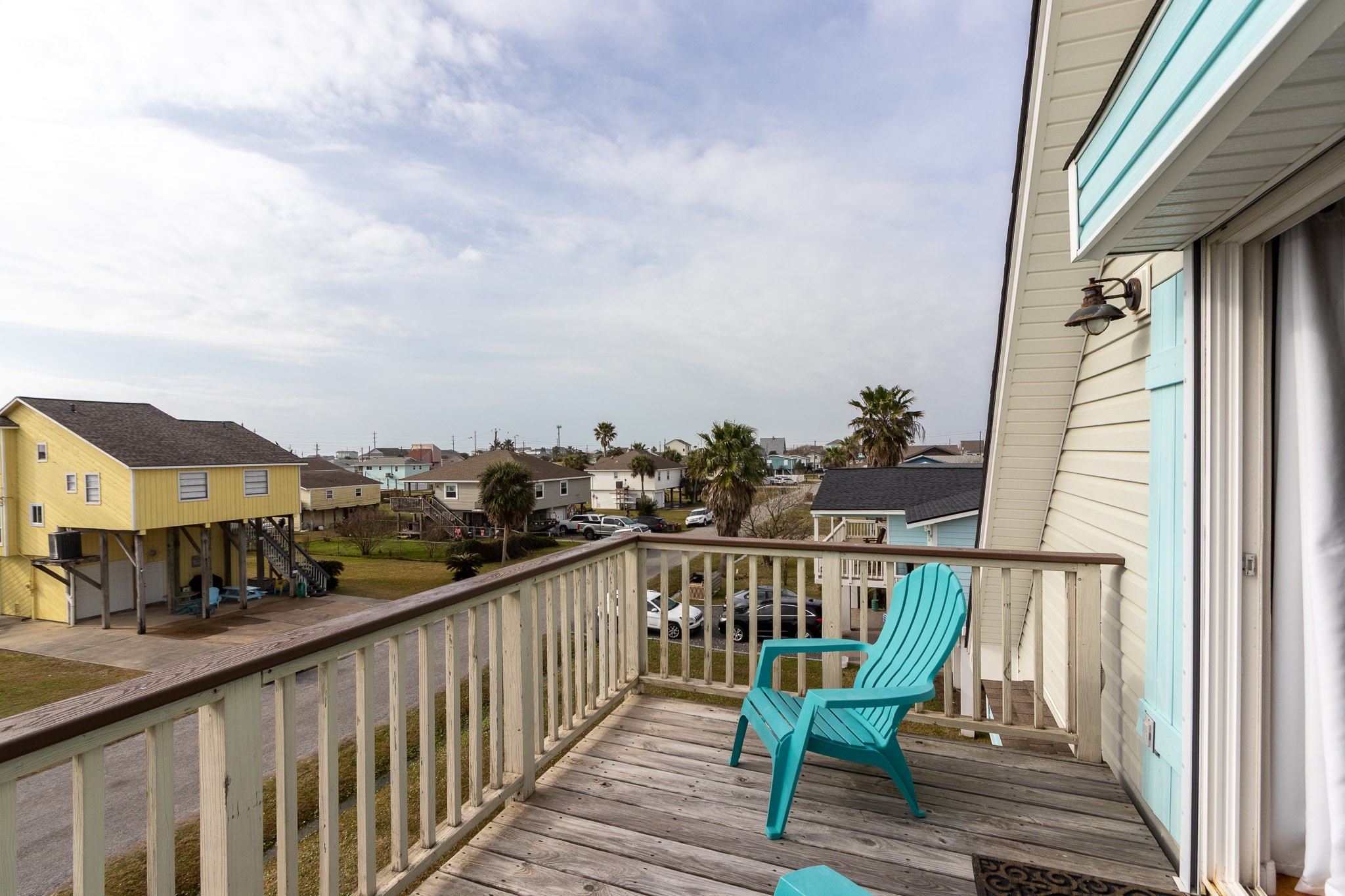 16518 Jean Lafitte Road Jamaica Beach, TX 77554 - Photo 25 of 43 a view of a balcony with wooden chairs and floor to ceiling window