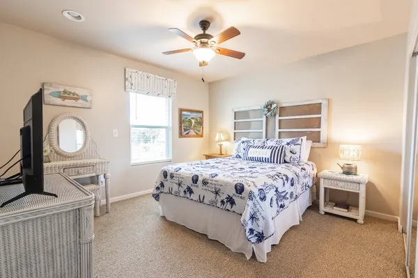 a bedroom with a bed a chandelier and dresser