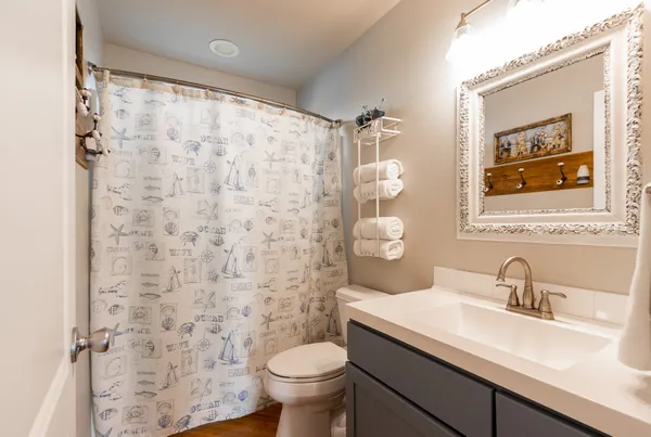a bathroom with a sink a toilet and shower curtain