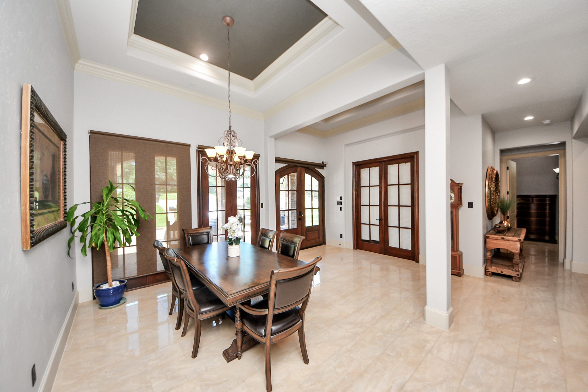702 Fairway Oaks Conroe, TX 77302 - Photo 11 of 42 This elegant dining room
features a high ceiling with a
stylish chandelier, polished tile
floors, and ample natural light
from large windows and French
doors. There's a sophisticated
wooden dining set and tasteful
decor, creating a welcoming
and upscale atmosphere.