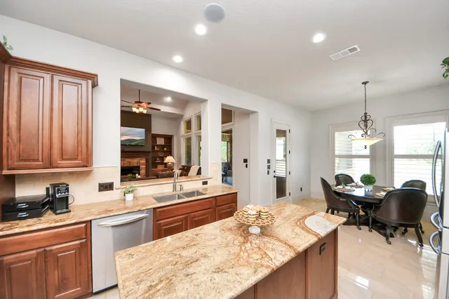 a kitchen with sink refrigerator dining table and chairs