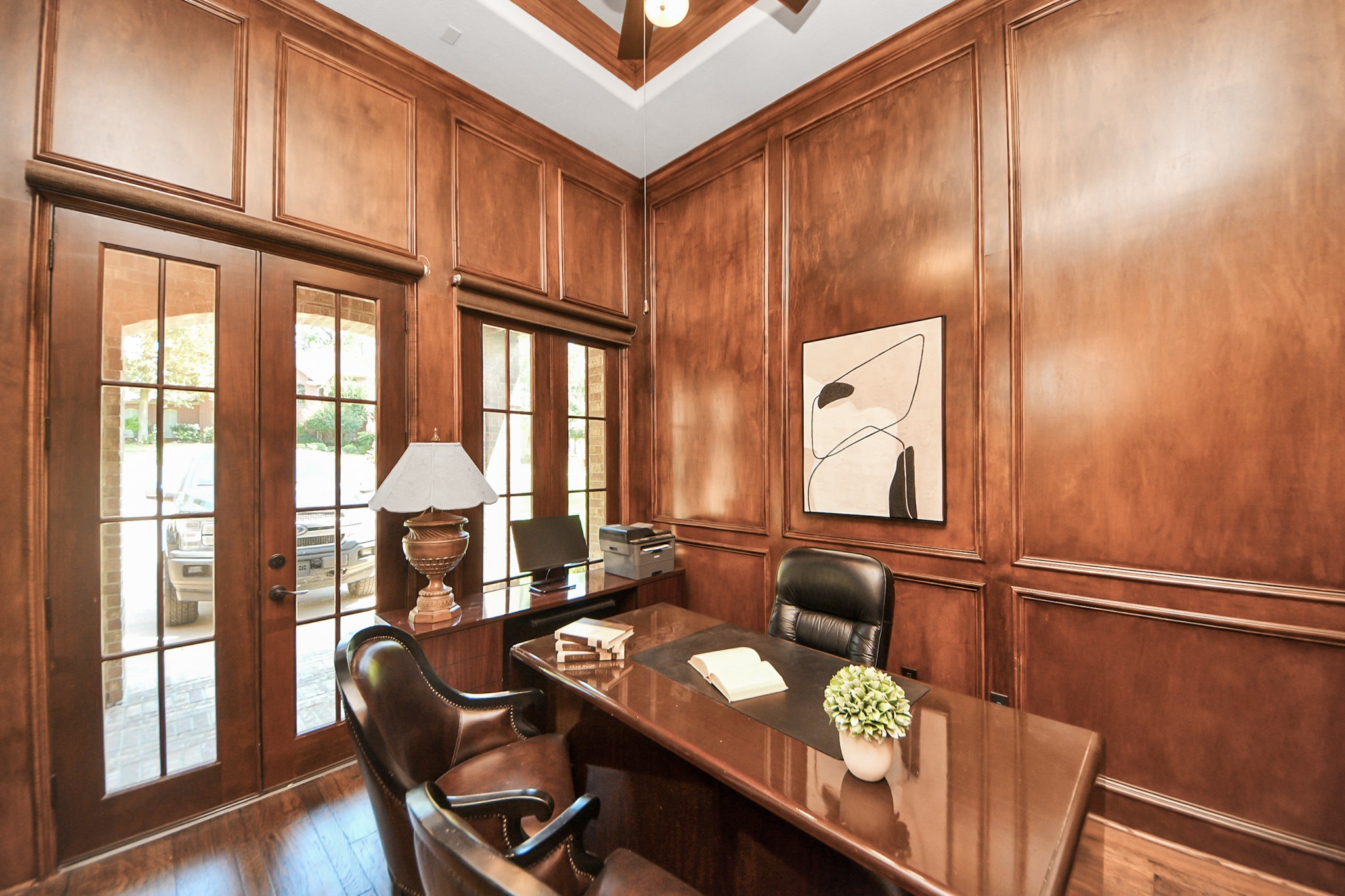 702 Fairway Oaks Conroe, TX 77302 - Photo 18 of 42 A sophisticated home office
with rich wood paneling. Large
glass doors offer ample natural
light, creating a warm and
inviting workspace.