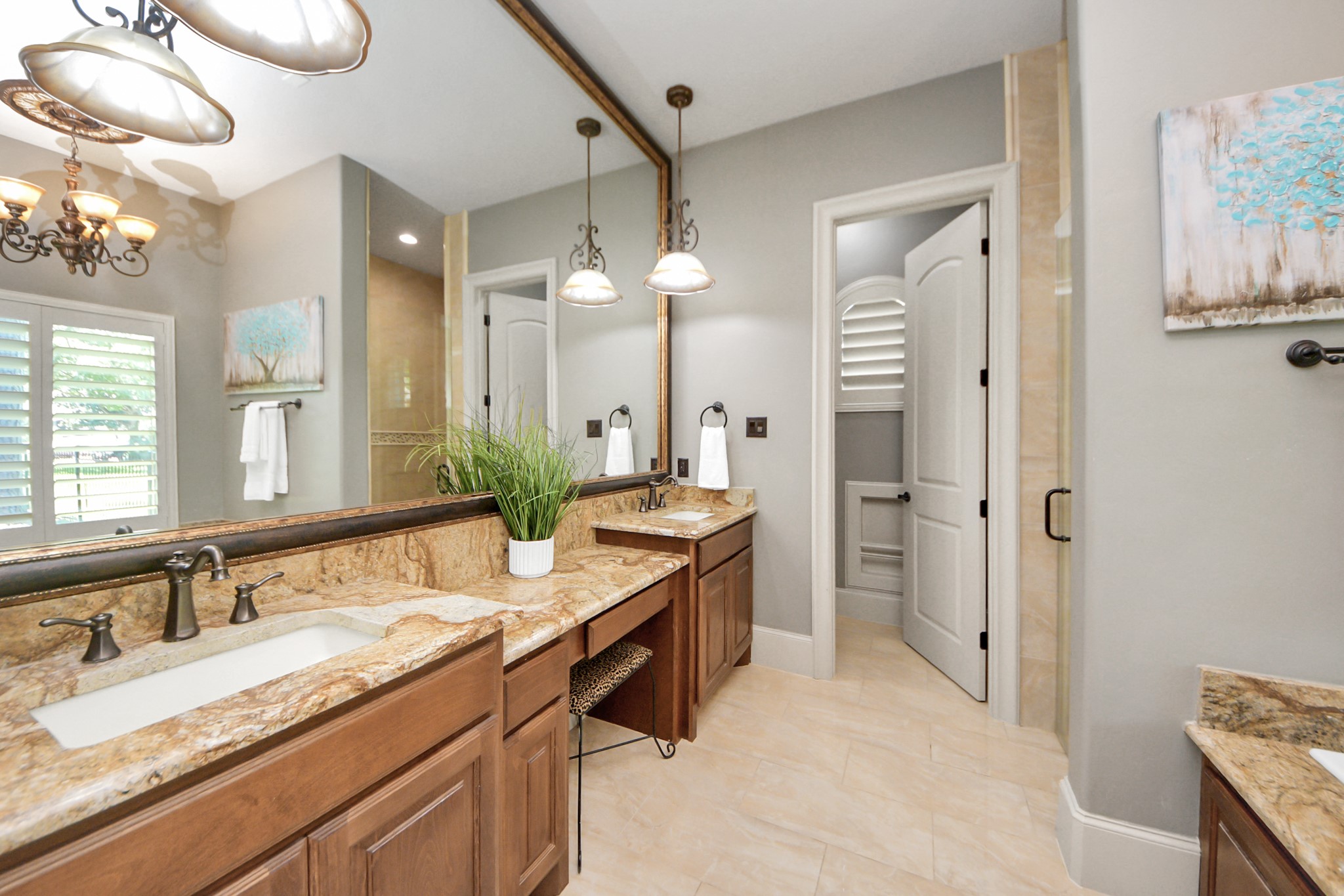 702 Fairway Oaks Conroe, TX 77302 - Photo 23 of 42 This primary bathroom features dual
sinks with elegant granite
countertops and wooden
cabinets. It has a large mirror,
stylish light fixtures, and neutral
tile flooring. A separate shower
area and ample natural light
complete the space.