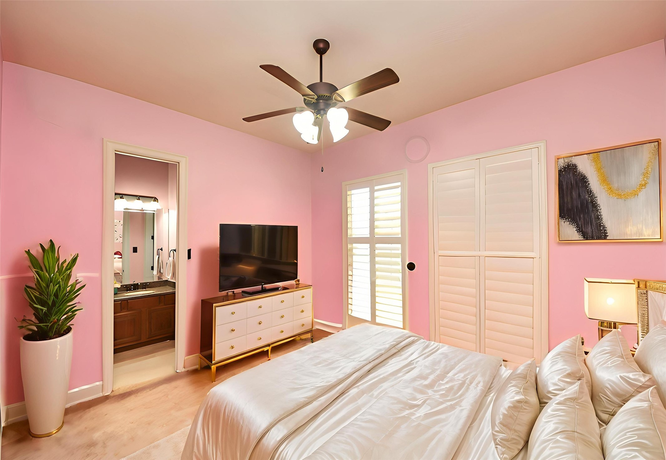 702 Fairway Oaks Conroe, TX 77302 - Photo 29 of 42 This cozy bedroom features
soft pink walls, a ceiling fan,
and natural light through
shuttered windows, and
connects to an ensuite
bathroom