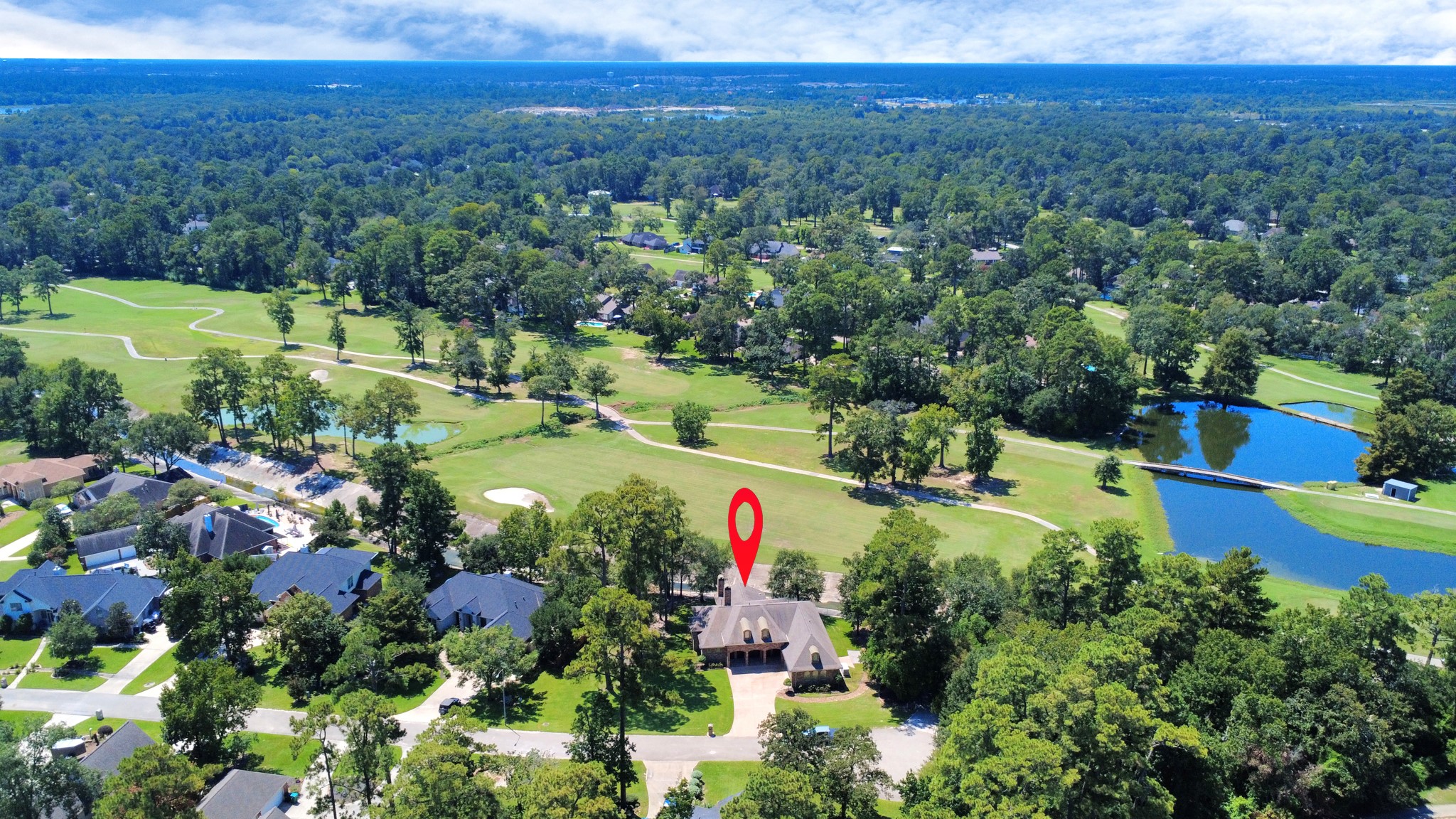 702 Fairway Oaks Conroe, TX 77302 - Photo 37 of 42 This photo showcases a
beautiful home located on a
spacious, lush property with
nearby water features and a
golf course. The surrounding
area is filled with greenery,
providing a serene and
picturesque environment