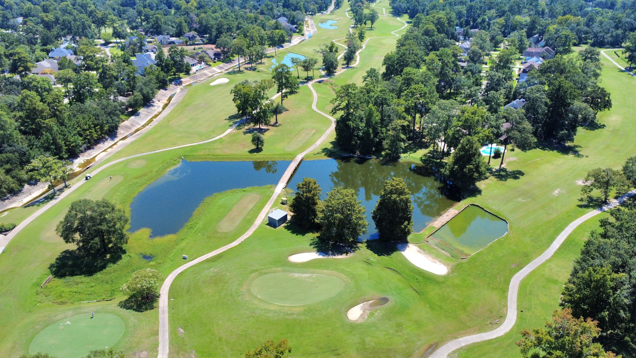 702 Fairway Oaks Conroe, TX 77302 - Photo 39 of 42 A lush golf course with winding
paths, water features, and sand
traps. It is surrounded by a
wooded area and nearby
residential homes, offering a
serene and picturesque setting
ideal for golf enthusiasts