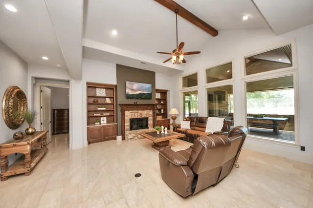 a living room with furniture a fireplace and a flat screen tv