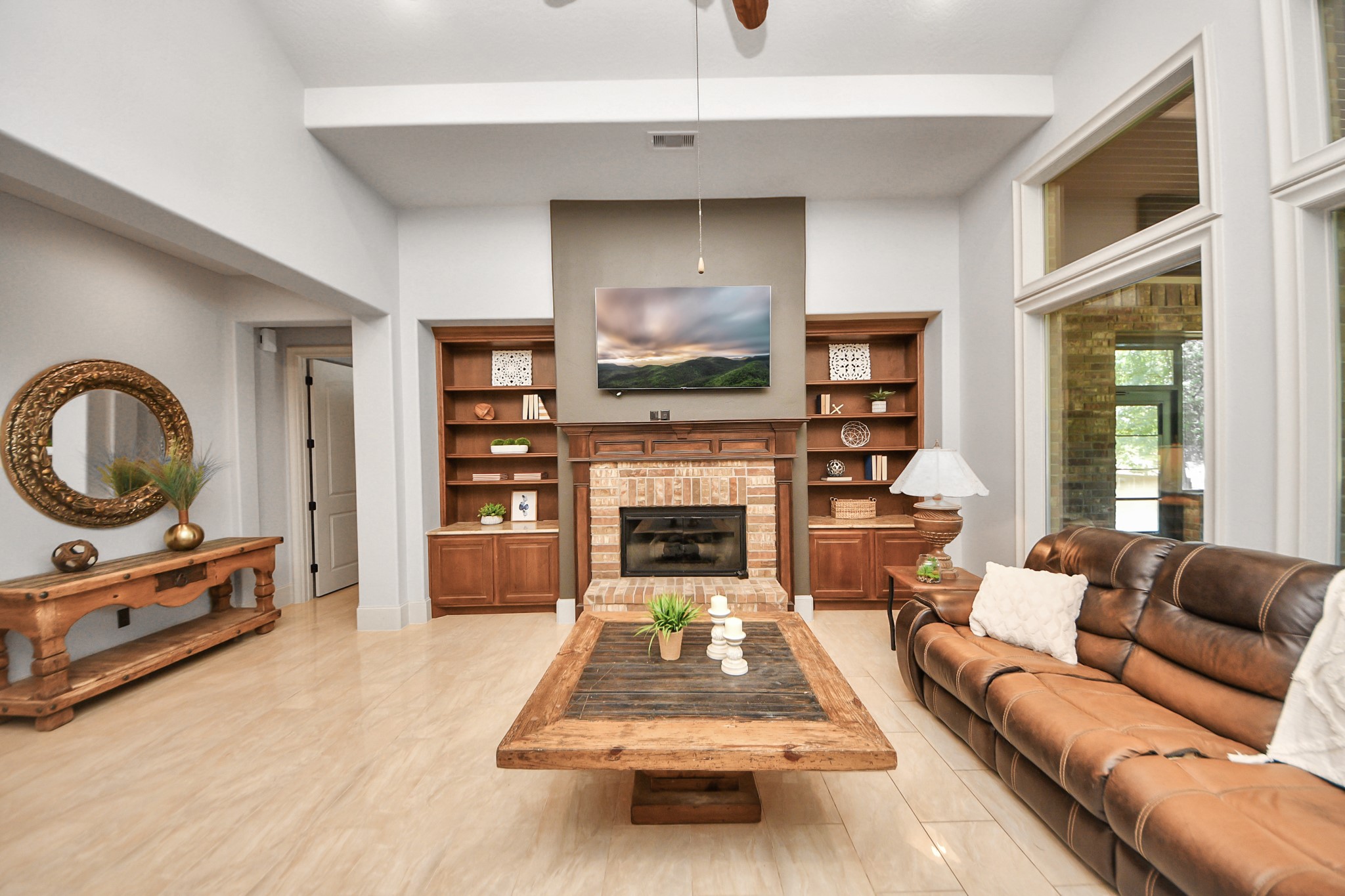 702 Fairway Oaks Conroe, TX 77302 - Photo 8 of 42 This inviting living room
features a high ceiling, a cozy
fireplace, and built-in wooden
shelves. Large windows
provide ample natural light.