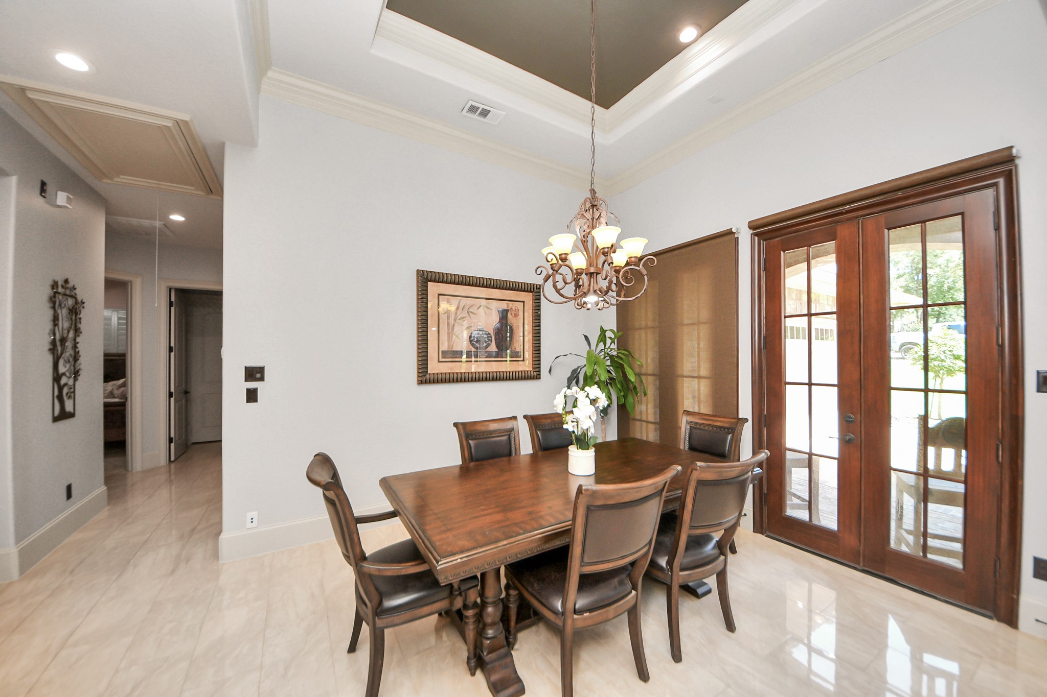 702 Fairway Oaks Conroe, TX 77302 - Photo 10 of 42 This elegant dining area
features a stylish chandelier
and French doors leading to
the outside. The room is bright
with neutral walls, a recessed
ceiling, and polished tile
flooring, offering a sophisticated
and inviting atmosphere.
