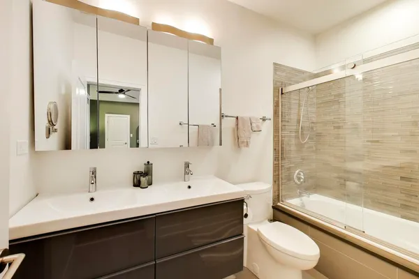 a bathroom with a sink a toilet and shower