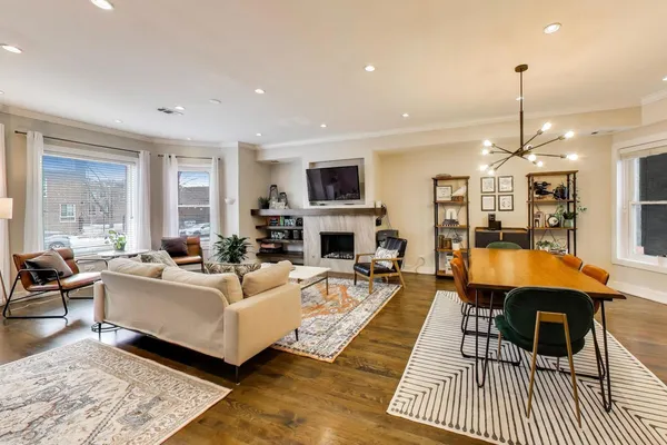 a living room with furniture a fireplace a flat screen tv and couches