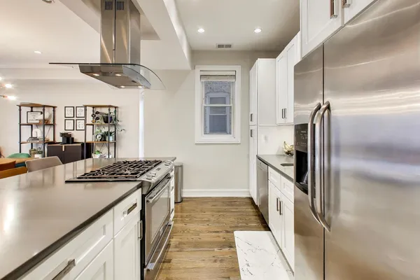 a kitchen with stainless steel appliances granite countertop a sink a stove and a refrigerator