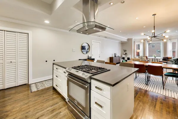 a kitchen with stainless steel appliances granite countertop a stove and a wooden floors