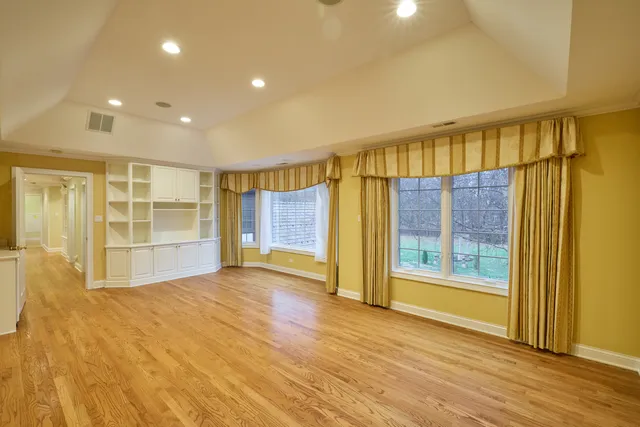 a front view of a house with garden and trees