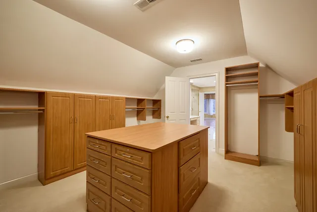 a view of a brick house with chairs and table in a patio