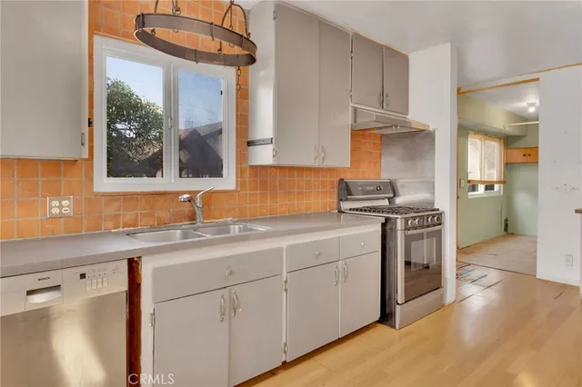 a kitchen with stainless steel appliances granite countertop a sink a stove and a refrigerator