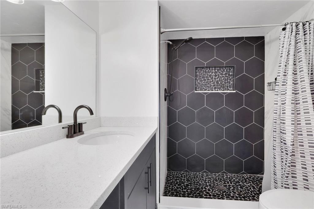 146 Cypress Way East, Unit 807 Naples, FL 34110 - Photo 19 of 27 a bathroom with a sink and a mirror