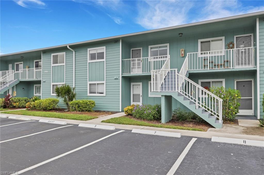146 Cypress Way East, Unit 807 Naples, FL 34110 - Photo 2 of 27 a front view of a house with a yard
