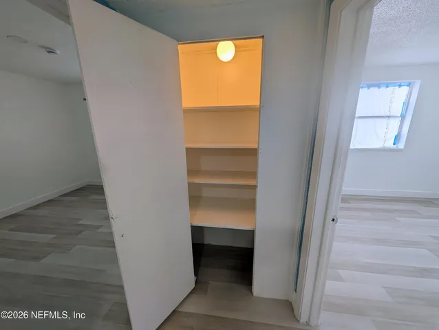 a view of walk in closet with empty racks