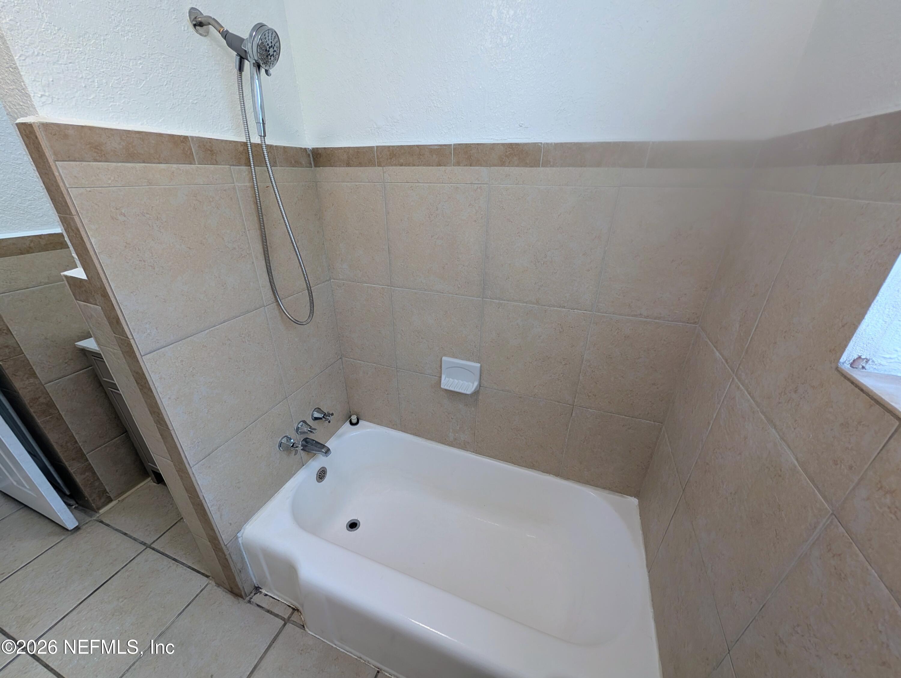 1454 Ribault Scenic Drive Jacksonville, FL 32208 - Photo 17 of 22 a bathroom with a white bath tub and a shower